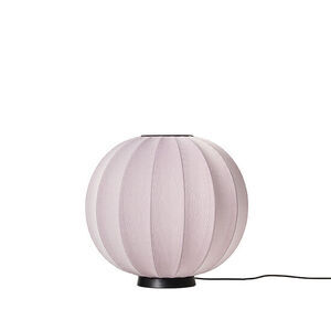 Rund lyserød lampe med tekstur, sort base. Blød, moderne æstetik.